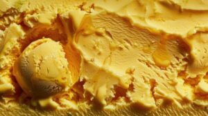 close up scoop of ice cream mango hint of chili heat lime vibrant orange color rich texture food related advertising summer themed content frozen treats flavour trends photo